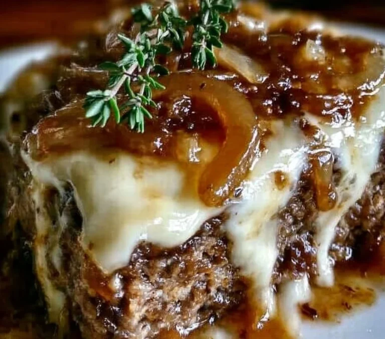 Crockpot French onion meatloaf with melted Swiss cheese in a serving dish