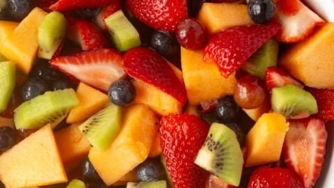 Colorful fruit salad for a crowd served in a large bowl with fresh fruits