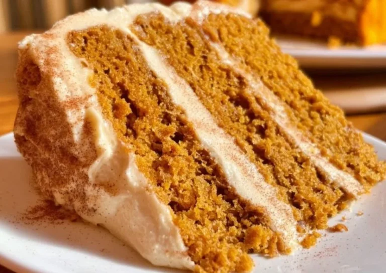 Sliced pumpkin cake with cinnamon cream cheese frosting on a plate