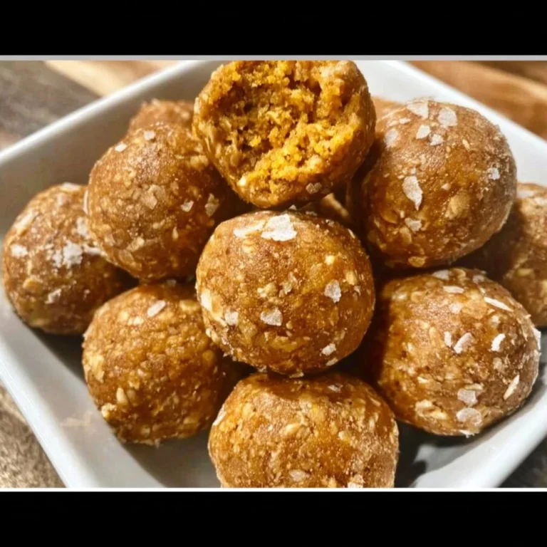 Homemade pumpkin protein balls stacked on a wooden table.