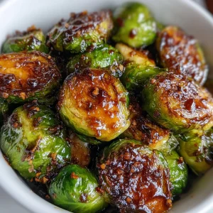 Crispy honey balsamic Brussels sprouts garnished with herbs.