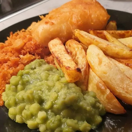 Crispy fish and chips with tasty bits served on a plate
