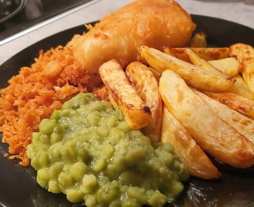 Crispy fish and chips with tasty bits served on a plate