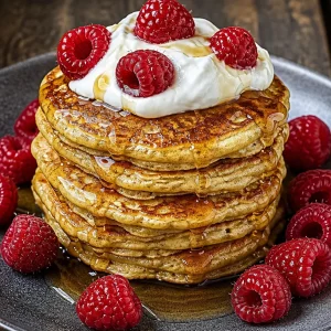 Stack of easy gluten-free oatmeal pancakes topped with fruit and syrup