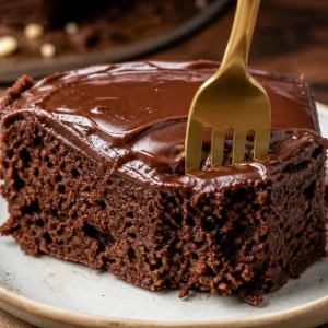 A slice of healthy Sweet Potato Chocolate Cake topped with chocolate frosting